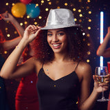 The image shows a silver sequin Borsalino-style hat, commonly used as a party accessory.